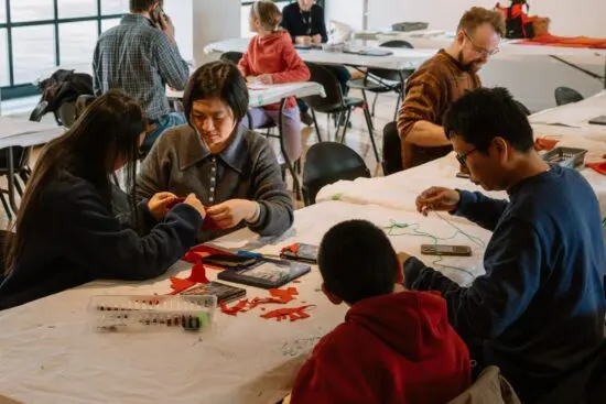 A family of four at a table making art together in The Making Place.