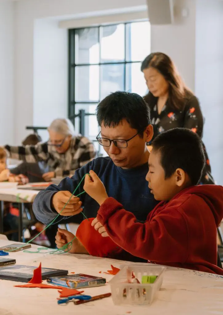 A father and son decorating a felted heart together at The Making Place.