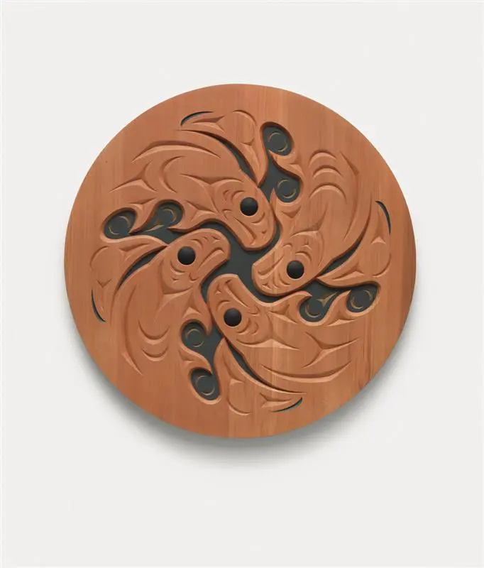 A sculpture by Susan Point of a wooden spindle whorl