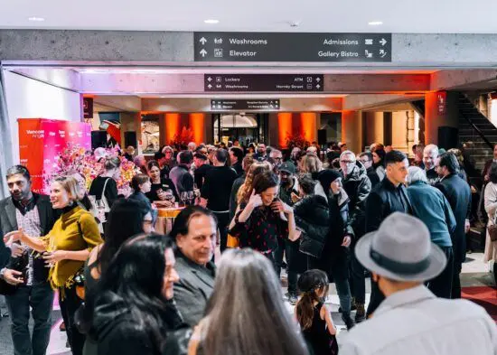 A crowd of people in the Gallery Lobby attending an exhibition opening reception.