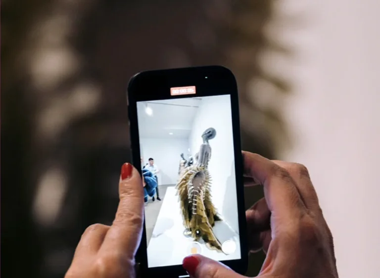 Detail shot of a person's hands holding an iPhone taking a picture of dress.