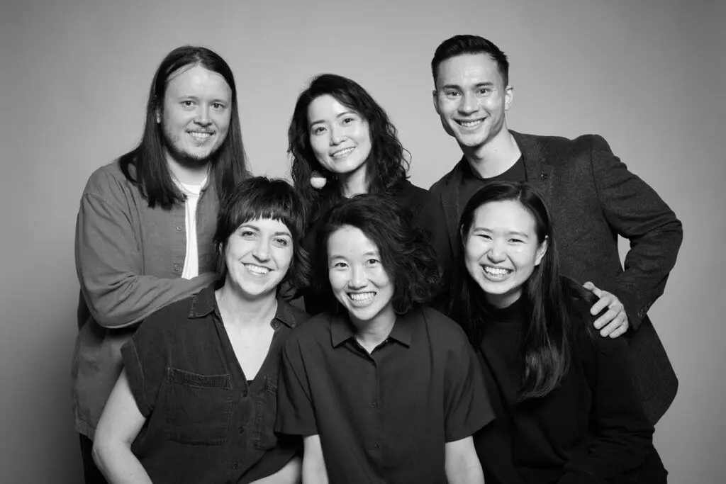 Group portrait in black and white of performers in Hong Kong Exile