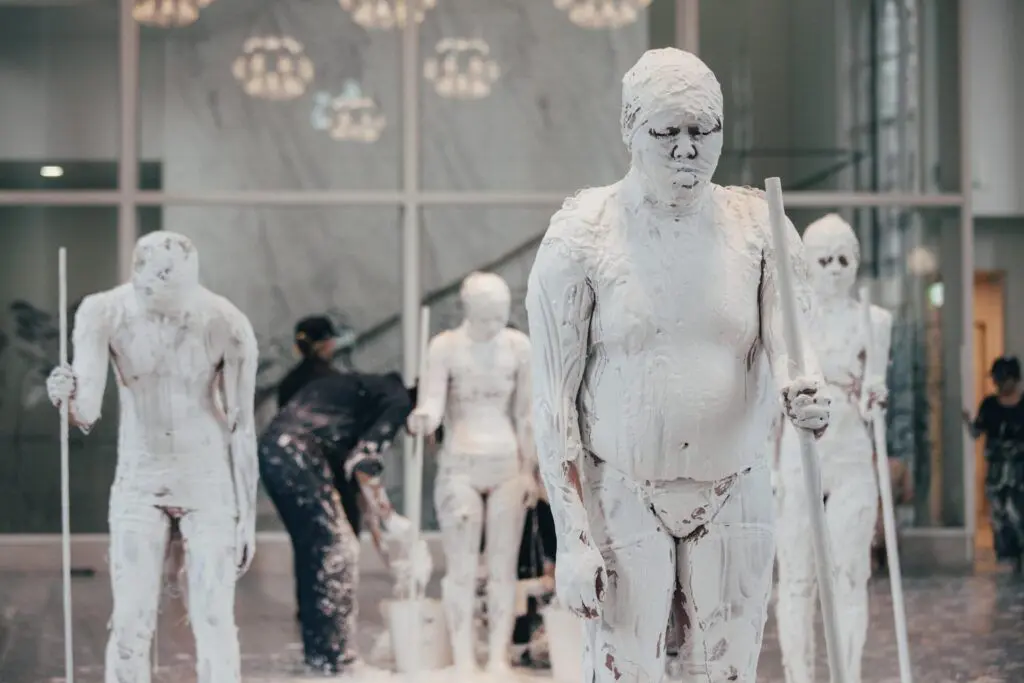 Figures are covered in white plaster as part of a performance directed by artist Tadasu Takamine.