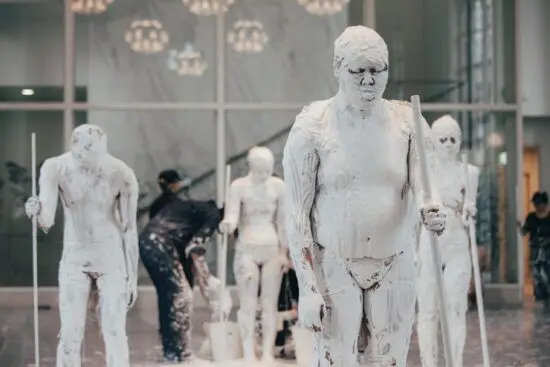 Figures are covered in white plaster as part of a performance directed by artist Tadasu Takamine.