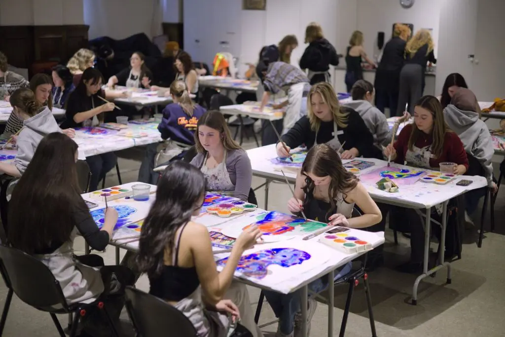 A classroom of teenage students sit at tables creating art during a Vancouver Art Gallery School Programs Workshop.