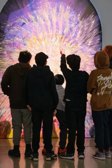 A school group looking at the art of Firelei Báez