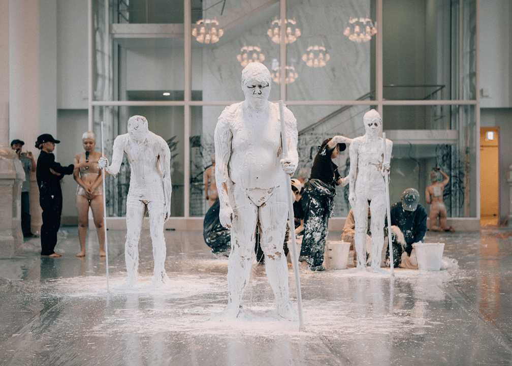 Figures are covered in white plaster as part of a performance by artist Tadasu Takamine.