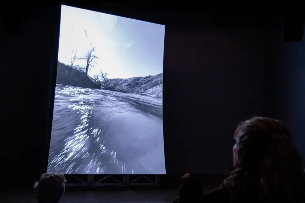 A towering vertical LED screen showing Lucy Raven's video work Murderers Bar.