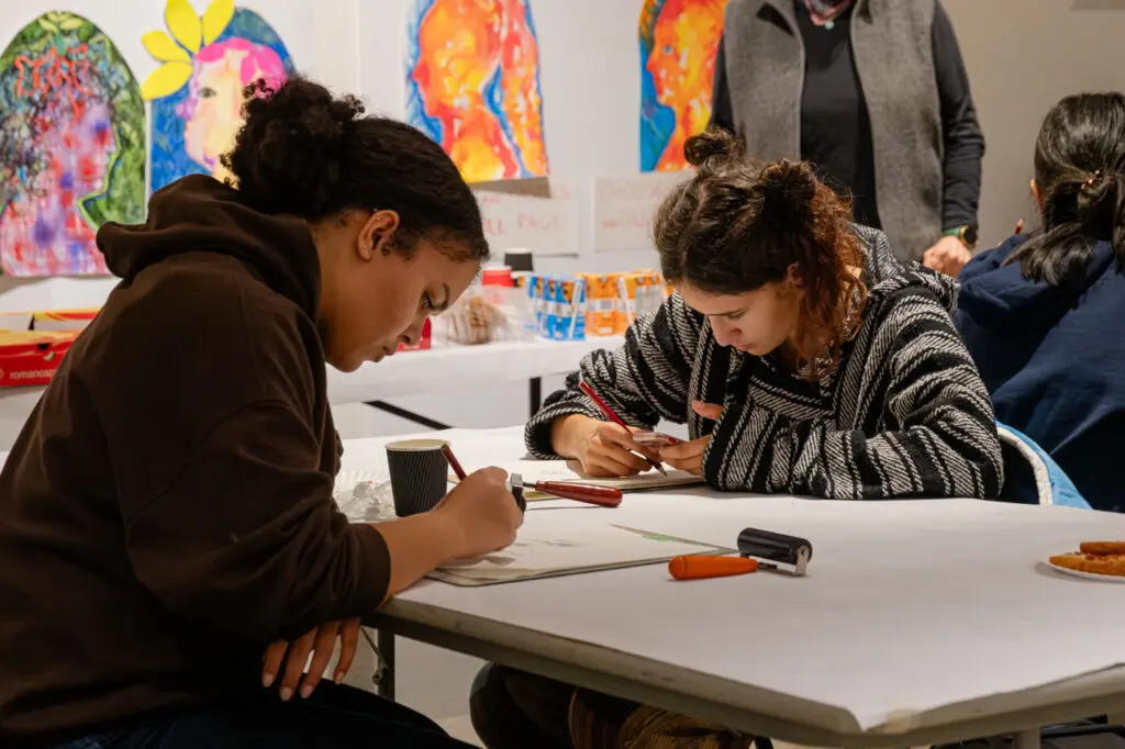 Two teens complete a drawing exercise.